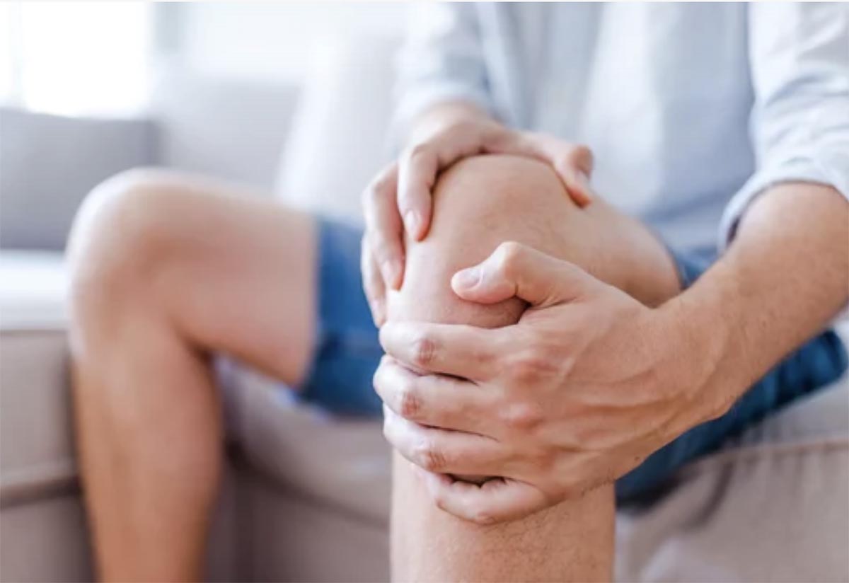A guy holds onto his knee as if in pain